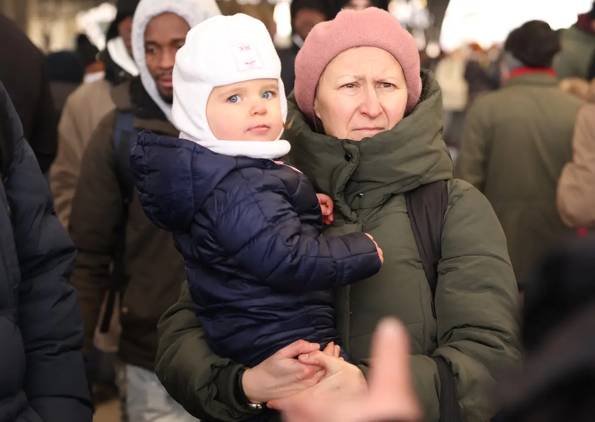 A woman carrying a small child waits to board an evacuation train at the railway station in Lviv, in Ukraine's westernmost corner, near the Polish border, on Feb 27, 2022