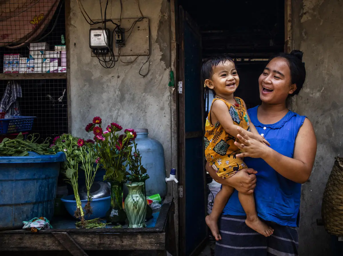 Pan Ei, 20 months old, and her mother play outside their hostel in A Lal village, Hlaing Thar Yar township, Yangon, Myanmar on April 4, 2022. 