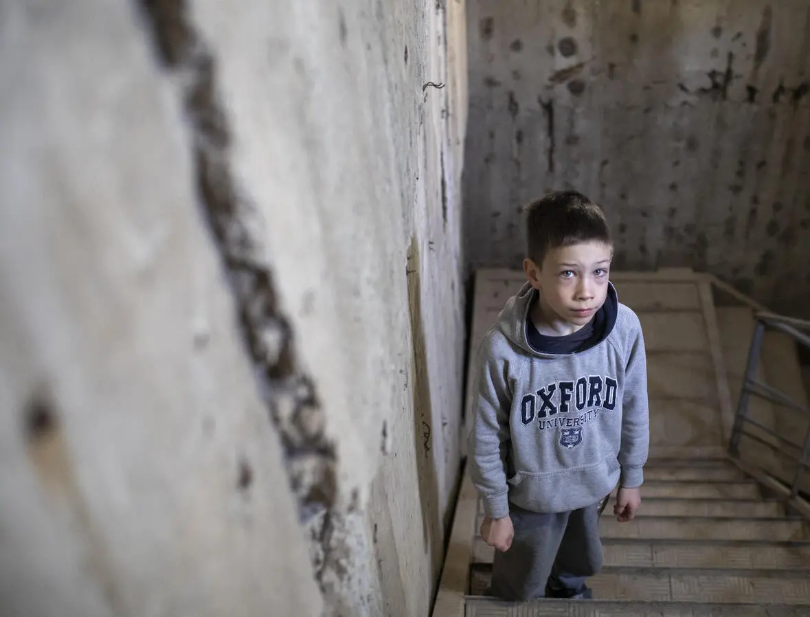 Artem, 9, from the northeastern city of Kharkiv, Ukraine, stands on the steps of the car park where families have been sheltering from air attacks and shelling.