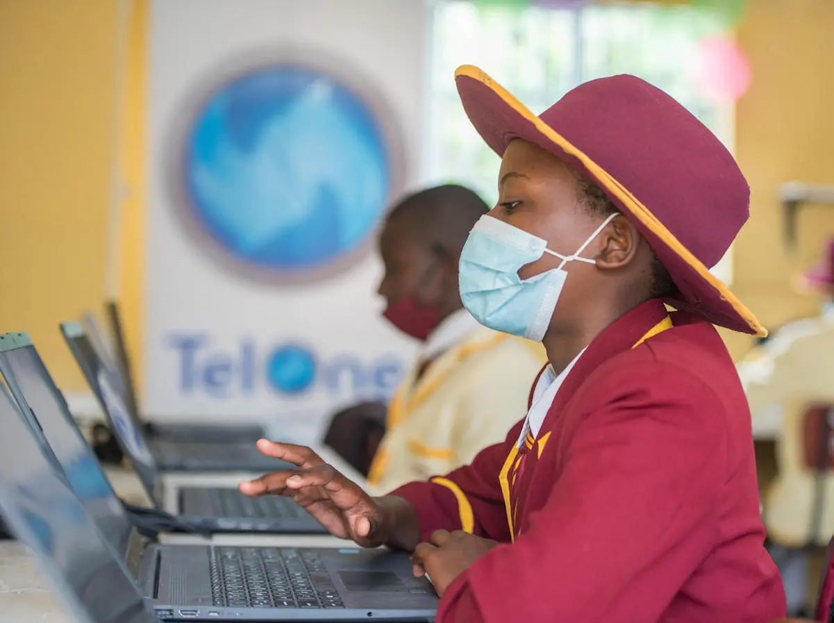 Girl in Hat and COVID Mask Using Computer