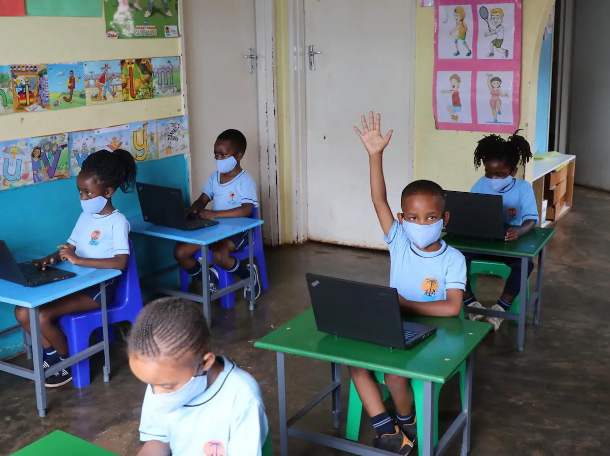 A student raises his hand to answer a question in a classroom at Oasis Primary School in Hartcliffe, Harare, Zimbabwe.