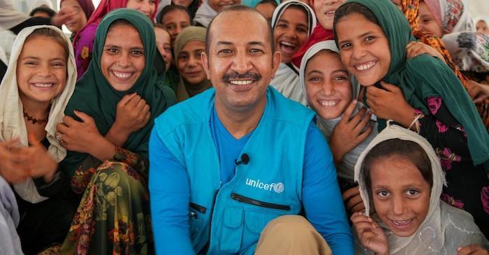 UNICEF Afghanistan Representative Dr. Mohamed Ayoya surrounded by children who benefit from UNICEF services and support.