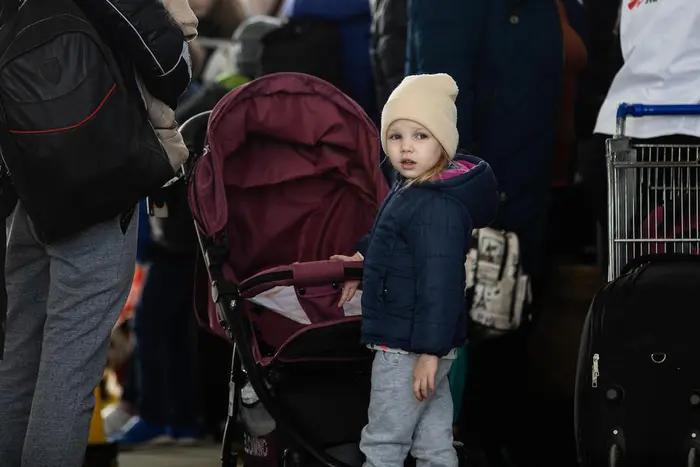 A child refugee from Ukraine stands in line with her mother at the border crossing between Ukraine and Moldova at Palanca on March 24, 2022. 