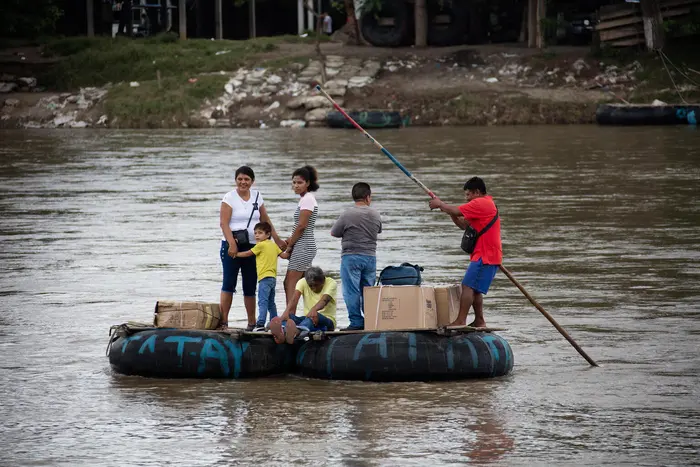 In Ciudad Hidalgo, Chiapas, Mexico, a makeshift raft is used to informally move people and products across the Suchiate River between Ciudad Hidalgo, Chiapas, Mexico and Ciudad Tec&uacute;n Um&aacute;n, Guatemala, on Oct. 12, 2022