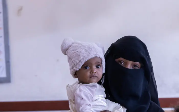 Married at 12, Yousra, 16, holds one of her two daughters in Taizz, Yemen. 