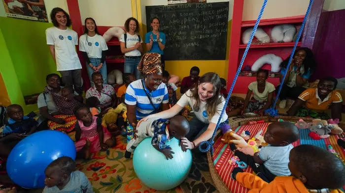 Visitors from UNICEF USA join a stimulation class for children under age 2 at the UNICEF-supported Kasunbanya Early Childhood Education Hub Insaka (Hub) in Zambia. 
