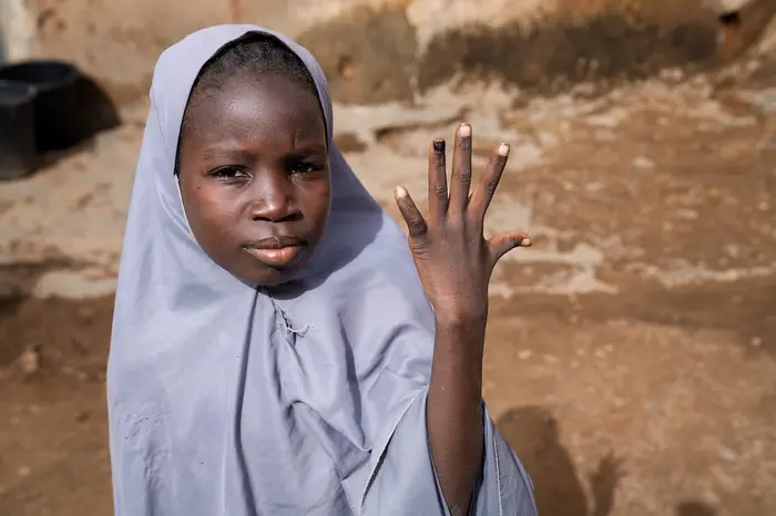 A 12-year-old girl in Katsina, Nigeria, shows her nail marked with ink indicating that she has been vaccinated against the human papillomavirus (HPV).