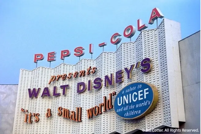 Entrance to Walt Disney’s ‘it’s a small world’ attraction at the World’s Fair. Over a cartoony cityscape sculpture, various midcentury modern fonts spell out 'Pepsi-Cola presents Walt Disney's 'it's a small world,' a salute to UNICEF and all the world's children.’