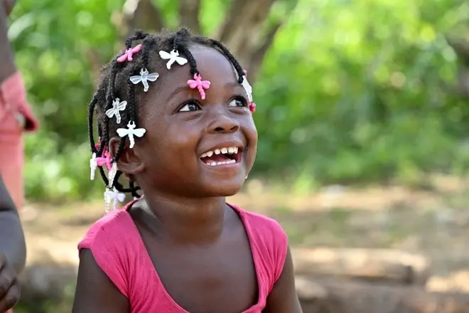 A young girl smiling while looking up.