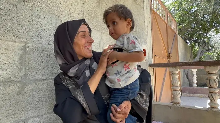 On Aug. 20, 2025, a mother holds her 1-year-old son in Deir Al Balah, Gaza, where UNICEF delivered lifesaving nutrition supplies. 