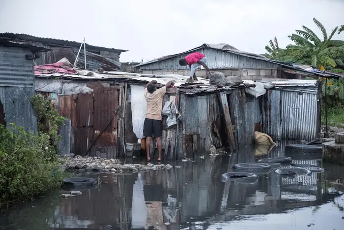 On Oct. 29, 2025, a family repairs their flooded home damaged by Hurricane Melissa in the southern region of Les Cayes in Haiti.