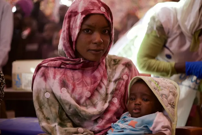 On Jan. 7, 2026, a mother holds her baby during a UNICEF-supported measles and rubella catch up campaign in Tawila, North Darfur, Sudan.