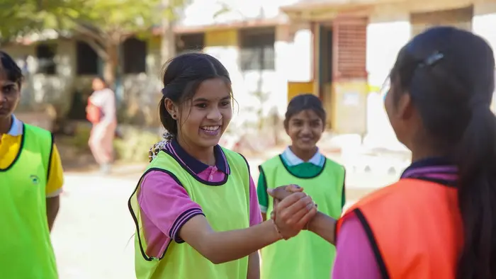 Two female captains from both teams come together before the start of play at a residential school in India. 