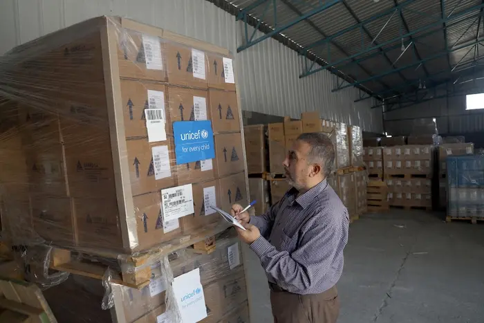 In Gaza Strip, a man checks supply boxes arriving from UNICEF.