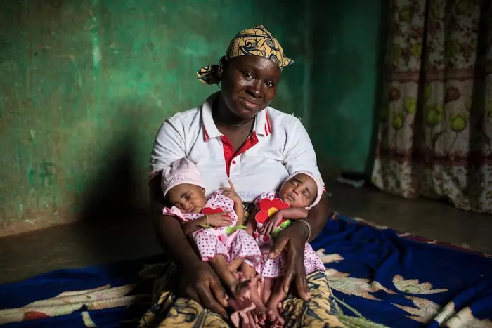 A mother in Mali cradles her twin babies.