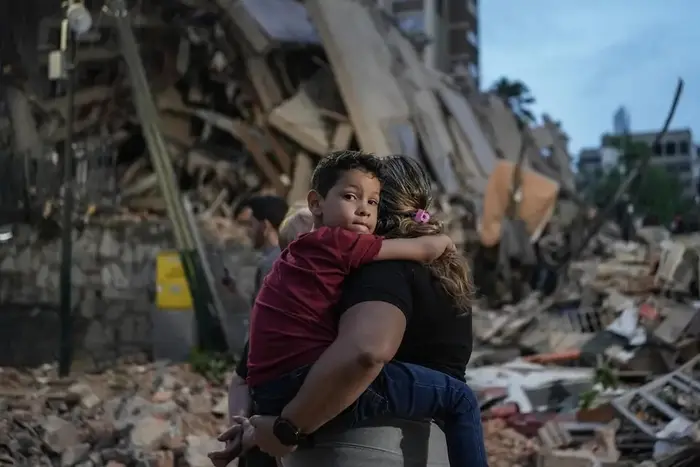 In Caracas, Venezuela, a boy is held by his mother near a building damaged by the earthquake.