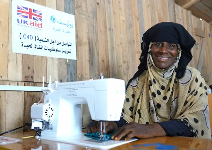 At an IDP center in Aden, Yemen, Umm Ibrahim, a member of a UNICEF-supported mothers' group, sews masks to protect families in her community from the spread of COVID-19. 