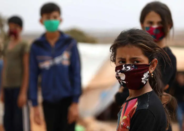 On 27 July 2020, children wear face masks sewn by displaced Syrian women at a camp for internally displaced persons near the town of Maaret Misrin in Syria's northwestern Idlib province, amidst the crisis of the COVID-19 pandemic.