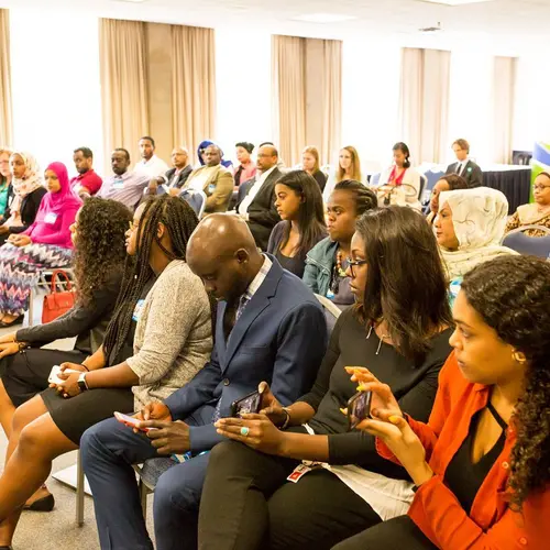 Audience members listen to panel of UNICEF and World Food Program Sudan Reps and Country Directors