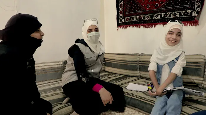 11-year-old Bara'a, a quadraplegic, photographed with her UNICEF case manager, a child protection specialist, and her mother during a recent virtual field visit.