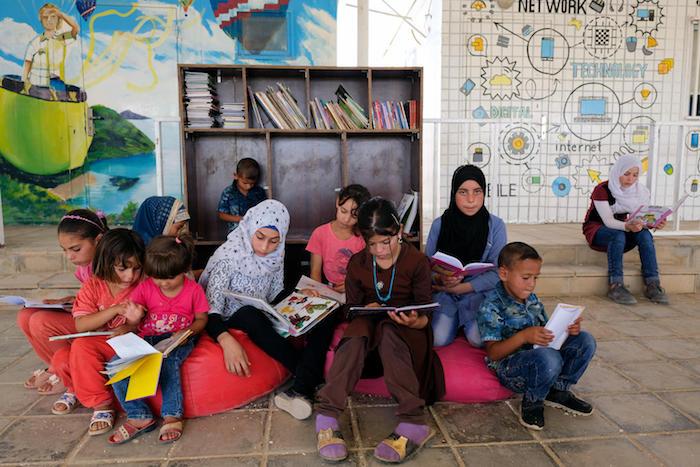 On 11 September 2017, Syrian girls and boys sit and read at a UNICEF-supported center for children in Za’atari refugee camp, Mafraq Governorate, Jordan. 