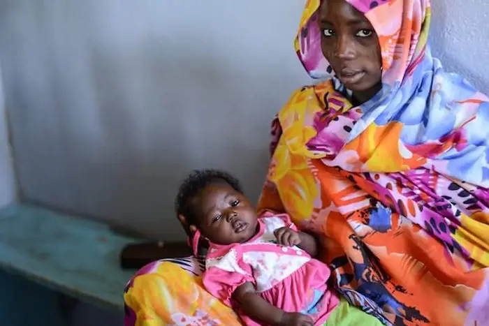A mother and child wait to be vaccinated by UNICEF and partners in Chad in February 2016.