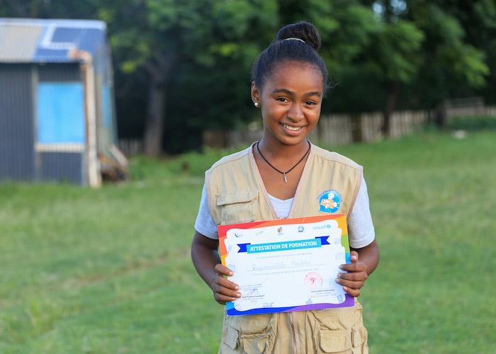 Christelle, 16, a member of the UNICEF-supporter Junior Reporters Club in Taolagnaro, Madagascar, holds her radio reporter's training certificate in 2019. 