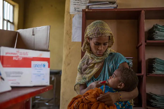 In Ethiopia, Marianna feeds 2-year-old Tamina a packet of Ready-To-Use Therapeutic Food at a UNICEF-supported health post where young children are screened for malnutrition.