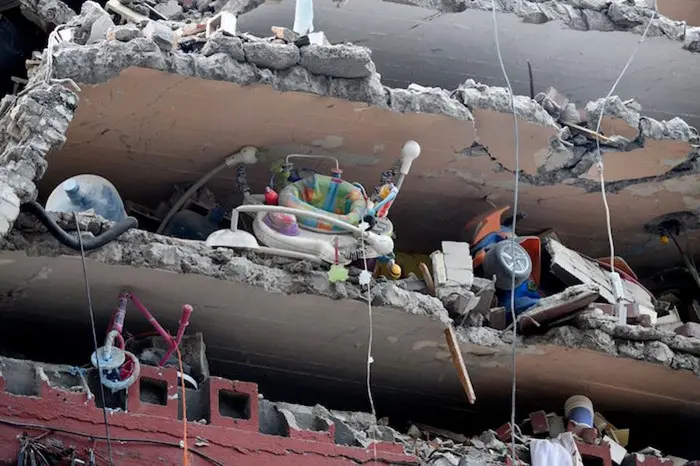 Toys and a walker are seen in a building flattened by the earthquake that shook Mexico City on September 18, 2017. 