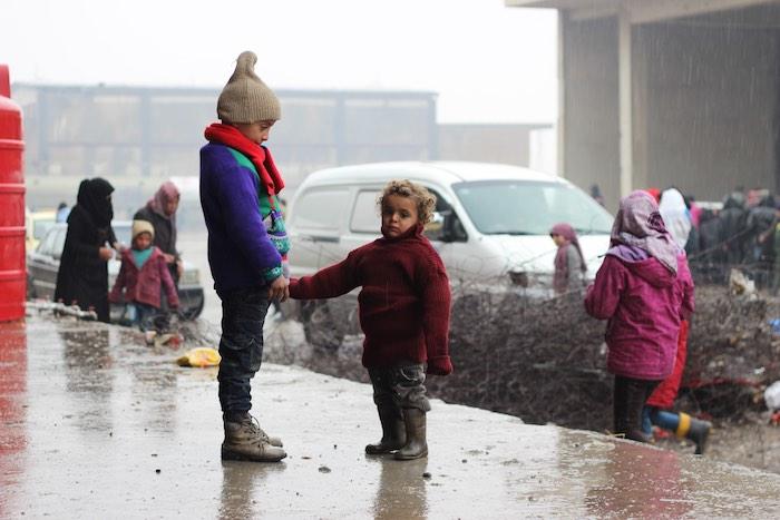 Children stand in the yard of a large warehouse in Jibreen, now used as a shelter for thousands of families who fled violence in east Aleppo. It is reported that some 31,500 people have been displaced from and within the area since 24 November. 