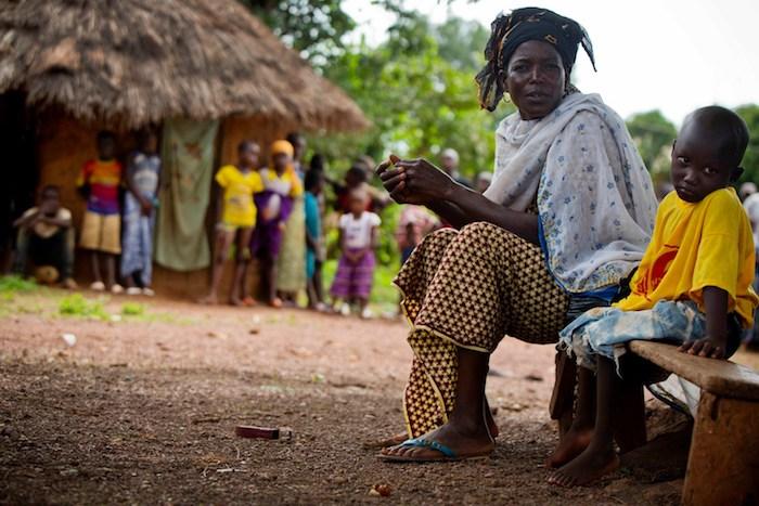 In Siguiri, Guinea, Sita sits beside her grandson, Lounceny, who contracted polio as a baby because he was not vaccinated. 