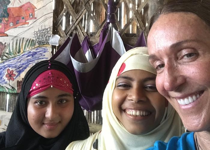 UNICEF USA board member Dolores Gahan takes a selfie with two young girls she meets at a Rohingya refugee youth center.