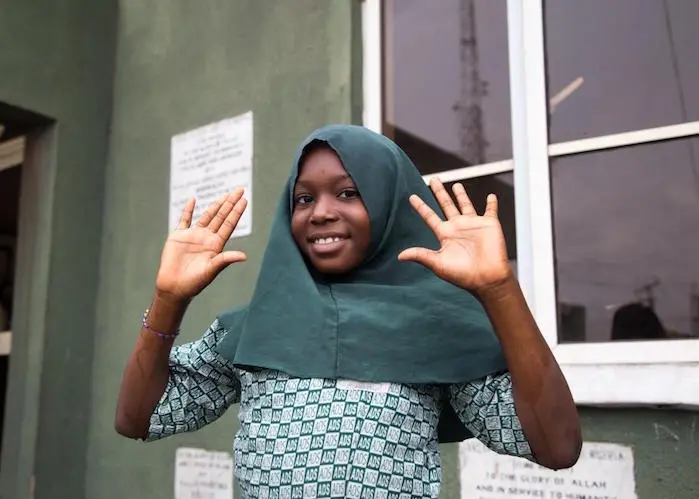 In Lagos, Nigeria, a girl shows her clean hands after learning how to wash them properly at a UNICEF-supported COVID-19 public awareness event in March 2020. 