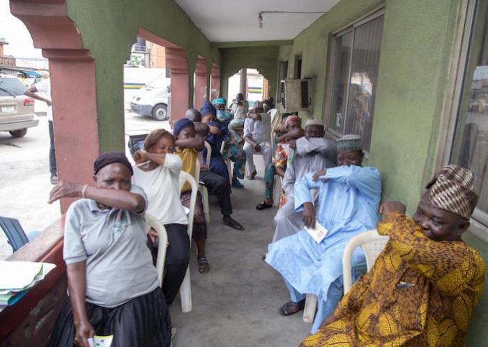 At a UNICEF-supported COVID-19 public awareness in Lagos State, Nigeria in March 2020, participants practice coughing into their elbows to avoid spreading the novel coronavirus.