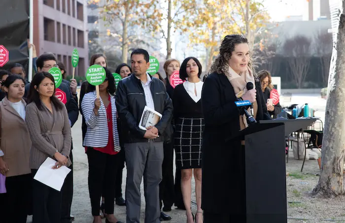 Kate Clark, senior director of immigration services for Jewish Family Service of San Diego, speaks at a recent event advocating for the rights of asylum seekers.