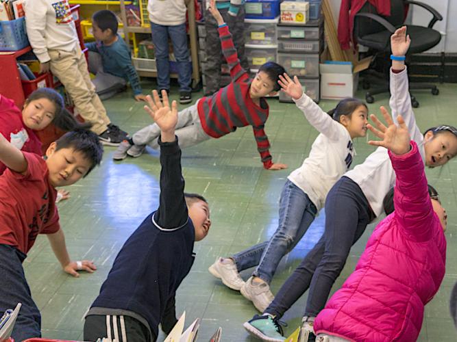 Students in Ms. Law's class at P.S. 42 take a "brain break" by doing a Kid Power Up.
