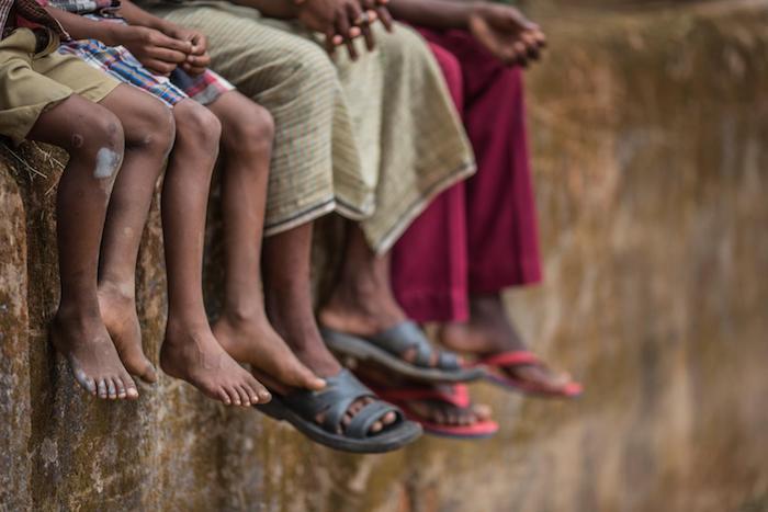 Children and adults sit on a wall in Chhattisgarh, India. UNICEF is implementing The Lion Project to help improve the lives of institutionalized children in Chhattisgarh and seven other states. 