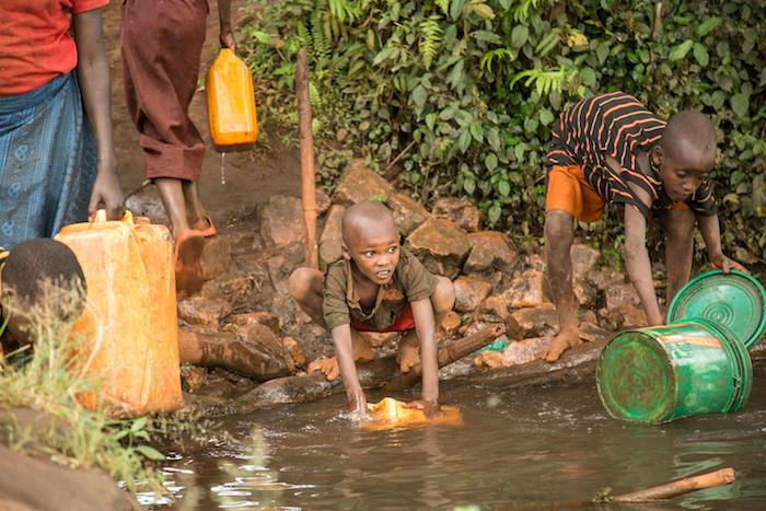 Children collect untreated water from a stream near their households in Ruyigi Province, Burundi, September 2017. 