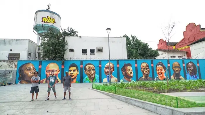 Rio street artists in front of the Mural they created to mark the first-ever Refugee Olympic Team. © UNHCR/Alex Colby