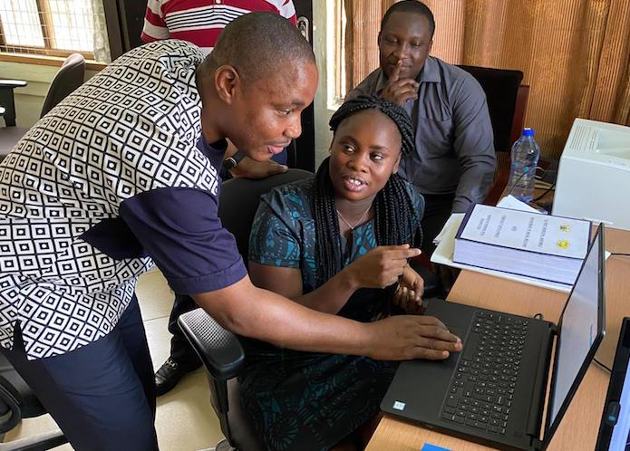 In Accra, Ghana, social worker Kingsley Agordo (far left, with colleagues) uses Primero, a case management system built by UNICEF and delivered by Microsoft, to locate and coordinate services for vulnerable children. 