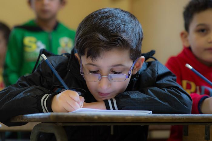 Lebanese and Syrian children study in double shifts at the UNICEF-supported Maalaka public boys school in Lebanon's Bekaa Valley. More than half the school's students are Syrian refugees.