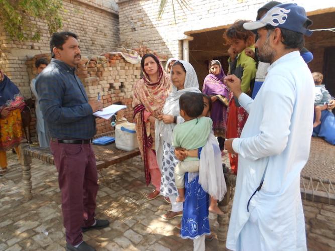 A UNICEF team member meets with community members in rural Pakistan to raise awareness about the importance of immunizations. 