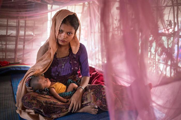 : Rohingya refugee Hazera Begum, 18, cradles her three-week-old after breastfeeding in a shelter she shares with her husband. 