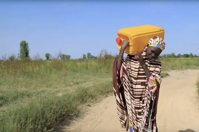 Thirteen-year-old Uzzayah Idris carrying water on her back for her family in Nigeria Thirteen-year-old Uzzayah Idris carrying water on her back for her family in Nigeria