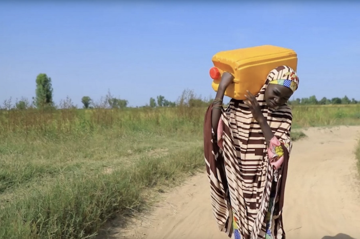 Thirteen-year-old Uzzayah Idris carrying water on her back for her family in Nigeria