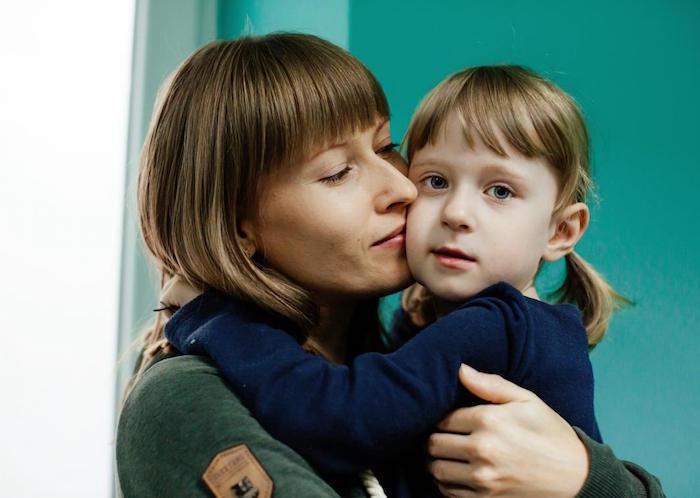A 4-year-old girl hugs her mother in a child development center supported by UNICEF in Lviv, Ukraine