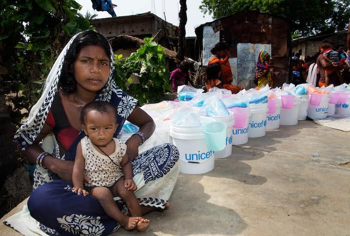 A woman and her child wait to receive relief items distributed by UNICEF, including a treated mosquito net and blankets, in Dhangar Tole ward no. 12, Gaur Municipality, Rautahat District, Nepal, Tuesday 22 August 2017.