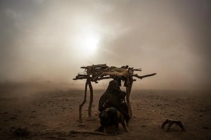 A woman weathers a dust storm on the outskirts of North Horr, Kenya, Wednesday, March 29, 2017. UNICEF, climate change