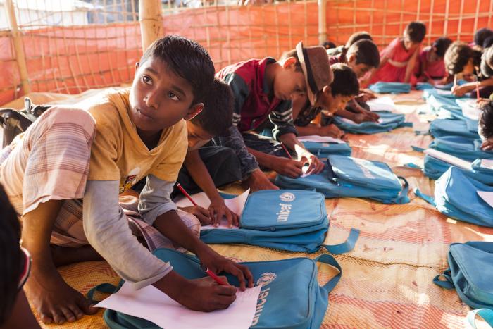 Rohingya refugee Rahmat Ullah, 12, who fled Myanmar by walking nonstop for two days and two nights with his family to the Myanmar-Bangladesh, attends a class at the Thainkhali makeshift settlement in Cox’s Bazar, Bangladesh