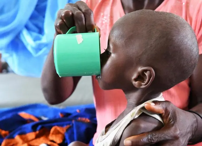 Veronique Kian gives her dehydrated 3-year-old granddaughter, Doris, milk formula at a UNICEF-supported health center in the village of Zouan Hounien in northwestern Côte d'Ivoire. Veronique Kian gives her dehydrated 3-year-old granddaughter, Doris, milk formula at a UNICEF-supported health center in the village of Zouan Hounien in northwestern Côte d'Ivoire.